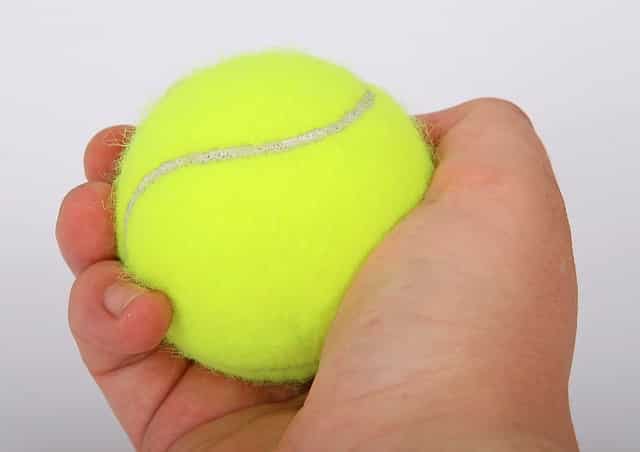 La main qui tient une balle de tennis représente la posture idéale pour freiner la progression de la rhizarthrose